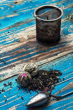 custard spoons, tea strainer on outdated wooden background turquoise color.tinted in vintage style