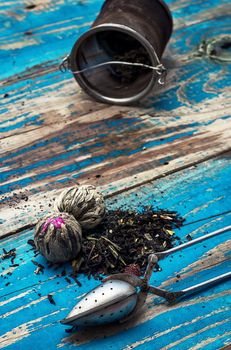 custard spoons, tea strainer on outdated wooden background turquoise color