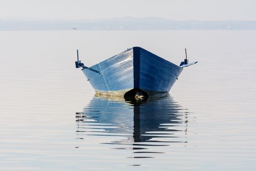 Bow of the boat is reflected in the water of the lagoon. Sardinia southwest, resort lagoon Bruncu Teula.