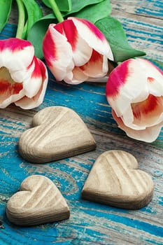 hand-carved symbolic wooden heart on a background red white Tulip