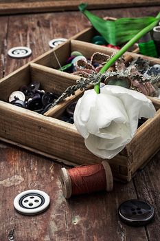 sewing accessories with a bouquet of fresh flowers.the image is tinted in vintage style