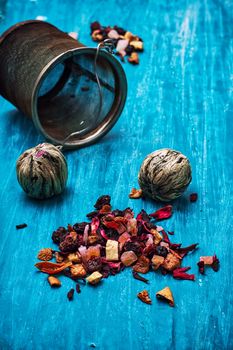 dried fragrant tea leaves on wooden turquoise background.Shallow DOF