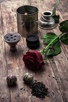 details hookah and dry elite tea leaves on wooden background.The toned image