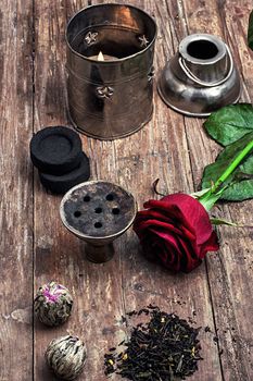 details hookah and dry elite tea leaves on wooden background.The toned image