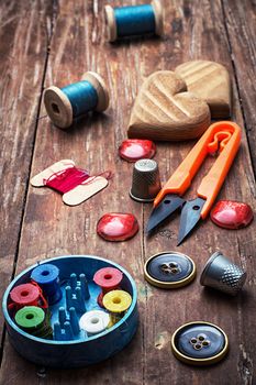 tools seamstresses on wooden background.the image is tinted in vintage style