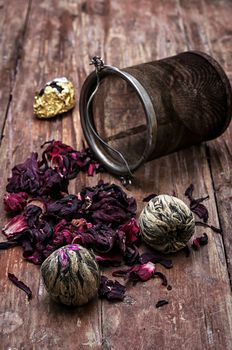 tea strainer and different varieties of tea leaves on wooden background.The toned image