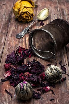 tea strainer and different varieties of tea leaves on wooden background.The toned image