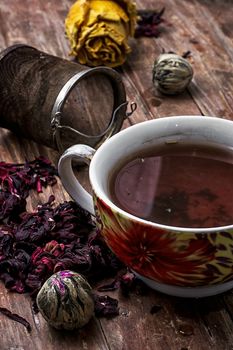 tea strainer and different varieties of tea leaves on wooden background.The toned image