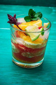 fresh juice from oranges,kiwi and grapefruit on turquoise wooden background.Selective focus