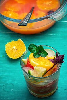 fresh juice from oranges,kiwi and grapefruit on turquoise wooden background.Selective focus