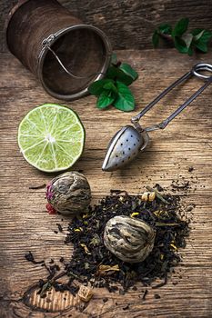 tea brew with lime and mint on wooden background in country style.Selective focus