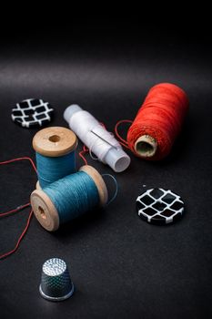 thread and buttons for sewing master on black background.Selective focus