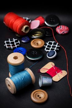 thread and buttons for sewing master on black background.Selective focus