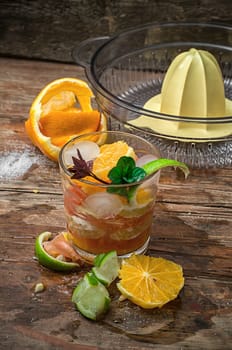fresh juice of tropical citrus fruits on wooden background in rustic style.Selective focus