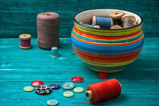 thread buttons for crafts on turquoise wooden background