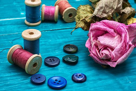 thread buttons for crafts on turquoise wooden background