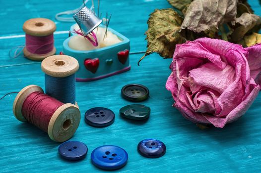 thread buttons for crafts on turquoise wooden background.Selective focus