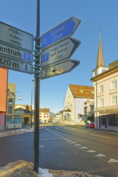 Road sign and Catholic Church in Bad Ragaz. Bad Ragaz is a city in canton St. Gallen in Switzerland.  It lies over Graubunden Alps. Spa and recreation village is at end of Tamina valley