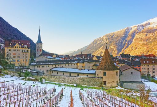 Church of St Martin and vineyard in Chur at sunrise. Chur is the capital of canton Graubunden in Switzerland. It lies in the Alpine Grisonian Rhine valley. The city is the oldest town of Switzerland