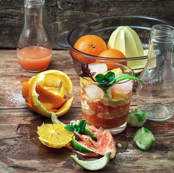 fresh juice of tropical citrus fruits on wooden background.Selective focus