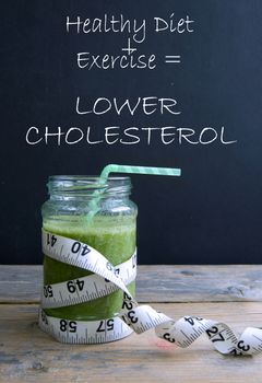 Healthy green smoothie with simple formula for lowering cholesterol written on a chalkboard 