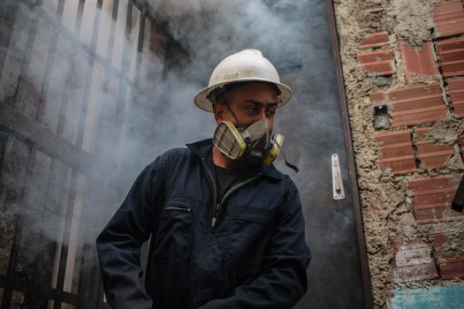 VENEZUELA, Caracas: A member of a fumigation crew exits a home after exterminating Aedes mosquitoes carrying the rapidly spreading Zika virus in the slums of Caracas, Venezuela on February 3, 2016. As of February 4, there have been reports of at least 255 cases of the rare Guillain-Barre syndrome  which causes the immune system to attack the nerves  potentially linked to the Zika virus in Venezuela.