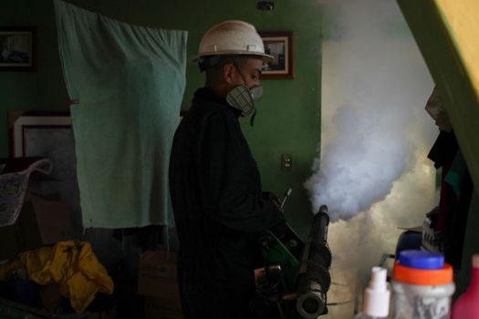 VENEZUELA, Caracas: A member of a fumigation crew works to exterminate Aedes mosquitoes carrying the rapidly spreading Zika virus in the slums of Caracas, Venezuela on February 3, 2016. As of February 4, there have been reports of at least 255 cases of the rare Guillain-Barre syndrome  which causes the immune system to attack the nerves  potentially linked to the Zika virus in Venezuela.