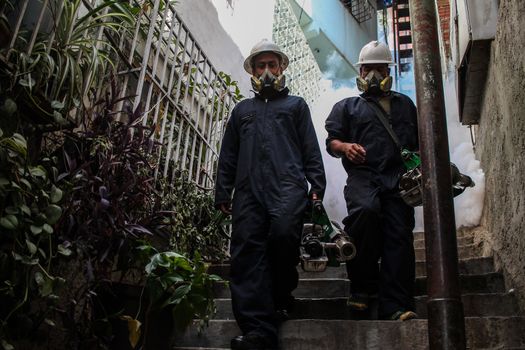 VENEZUELA, Caracas: Members of a fumigation crew exit a home after exterminating mosquitoes carrying the rapidly spreading Zika virus in the slums of Caracas, Venezuela on February 3, 2016. As of February 4, there have been reports of at least 255 cases of the rare Guillain-Barre syndrome  which causes the immune system to attack the nerves  potentially linked to the Zika virus in Venezuela.