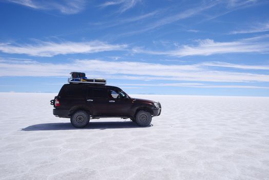 jeep travel in a large salt flat in uyuni, bolivia