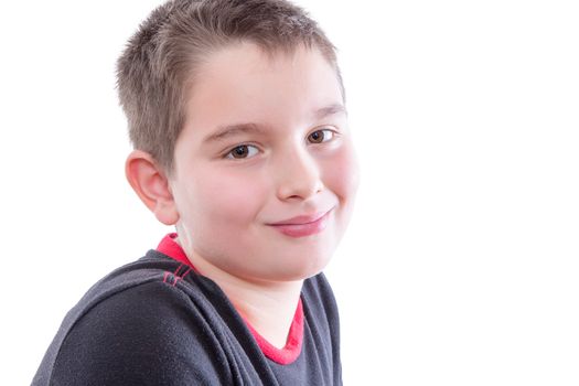 Head and Shoulders Close Up Portrait of Young Tween Boy Wearing Black and Red T-Shirt and Smiling Over Shoulder at Camera in Studio with White Background and Copy Space