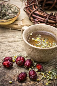 ceramic cup brewed with rose hips and chamomile in vintage rustic style