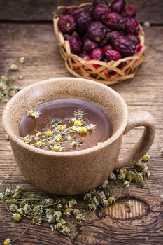 ceramic cup brewed with rose hips and chamomile in vintage rustic style