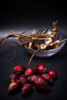 berries are dried rose hips and herbs on black background