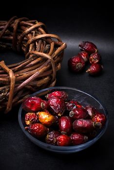 berries are dried rose hips and herbs on black background