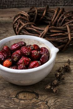 rose in white bowl on background licorice root bound in coil.Selective focus