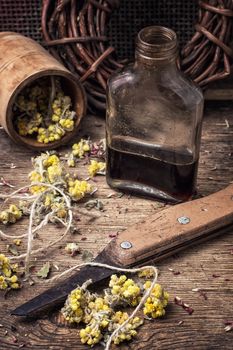 Herbs and glass bulb with decoction of them in rustic style.The image is tinted.