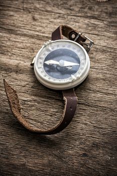 obsolete compass on wooden table top in retro style