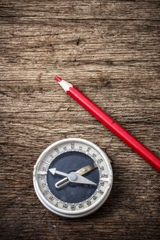 obsolete compass on wooden table top in retro style