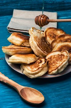 pancakes drizzled with jam on blue wooden board.