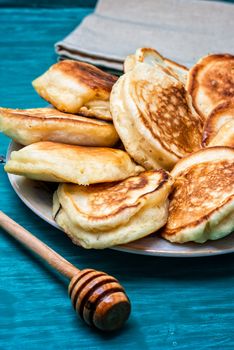 pancakes drizzled with jam on blue wooden board.