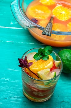 glass fresh citrus juice with pulp on the background of the vase with juice