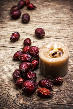 dried berries of the wild rose on wooden table in rustic style