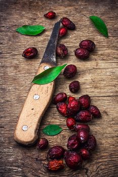 dried berries of the wild rose on wooden table in rustic style