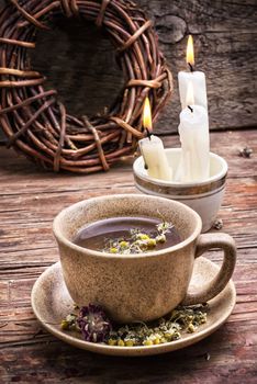 fragrant chamomile tea and burning candles in rustic style.Selective focus