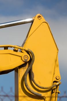 Detail of hydrolic Bulldozer piston (ram) against blue sky.