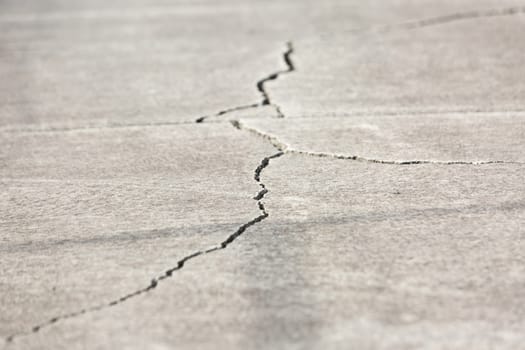 A Large crack in concrete pathway.