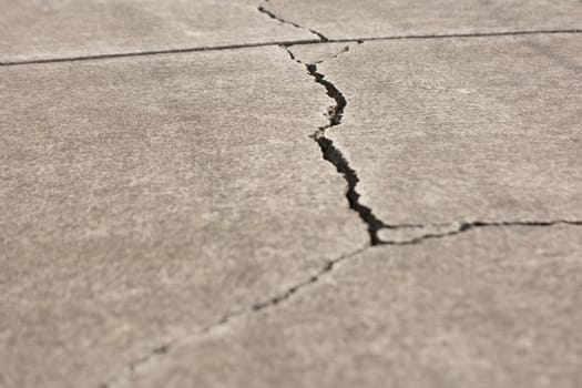 A Large crack in concrete pathway.