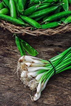 leek and green peas in basket in rustic style.The image is tinted