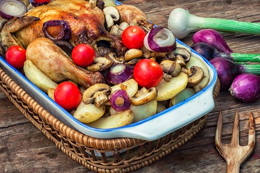 chicken baked with mushrooms,potatoes and vegetables in glass form.Photo tinted