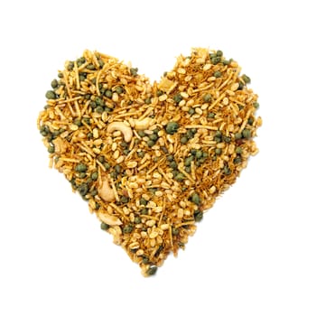 Pile of dry roasted Indian snack mix, heart-shaped, isolated over white